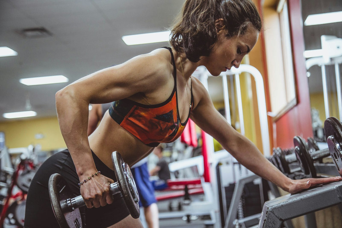 A lifter performing a slow, controlled dumbbell row with clean form in a quiet gym